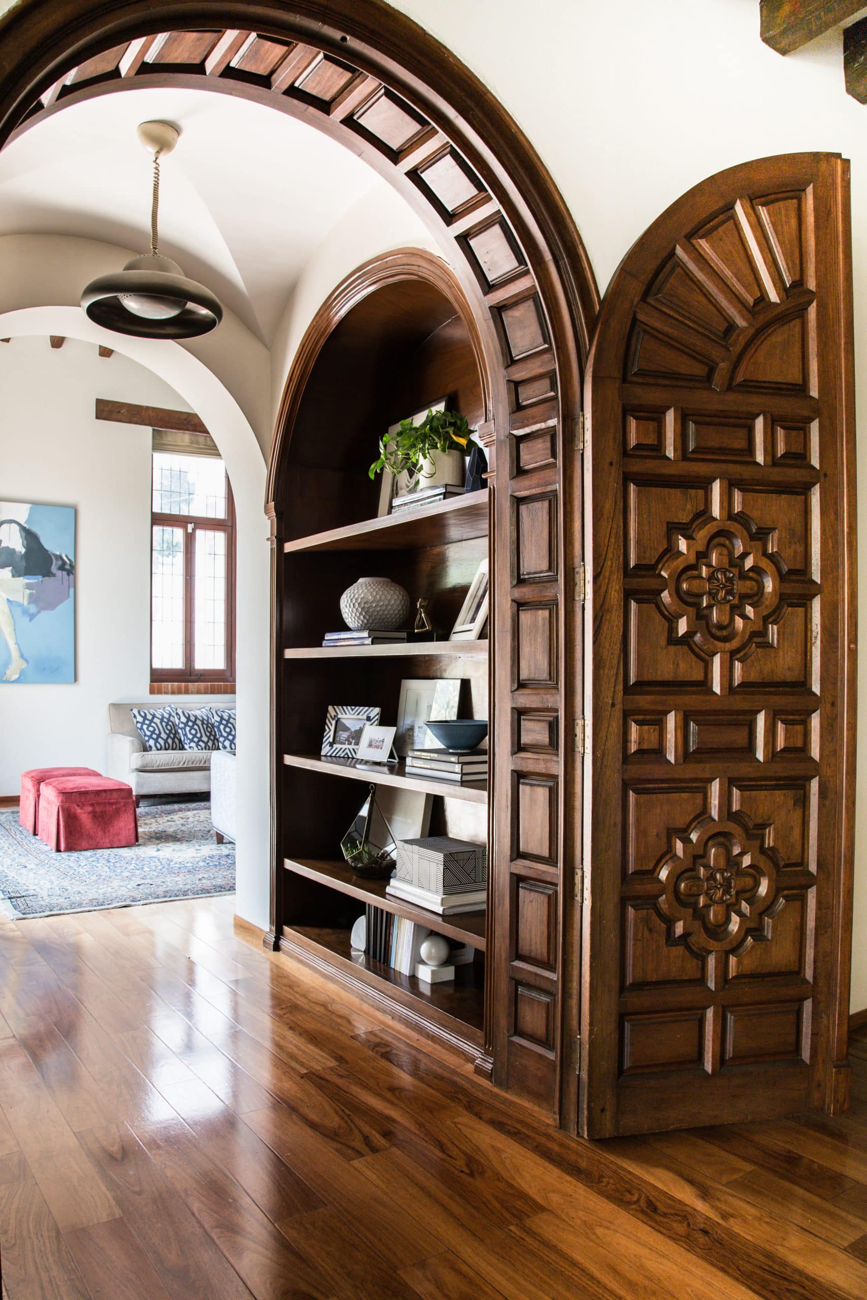Handcarved arched wooden doors with built-in shelving and curated styling