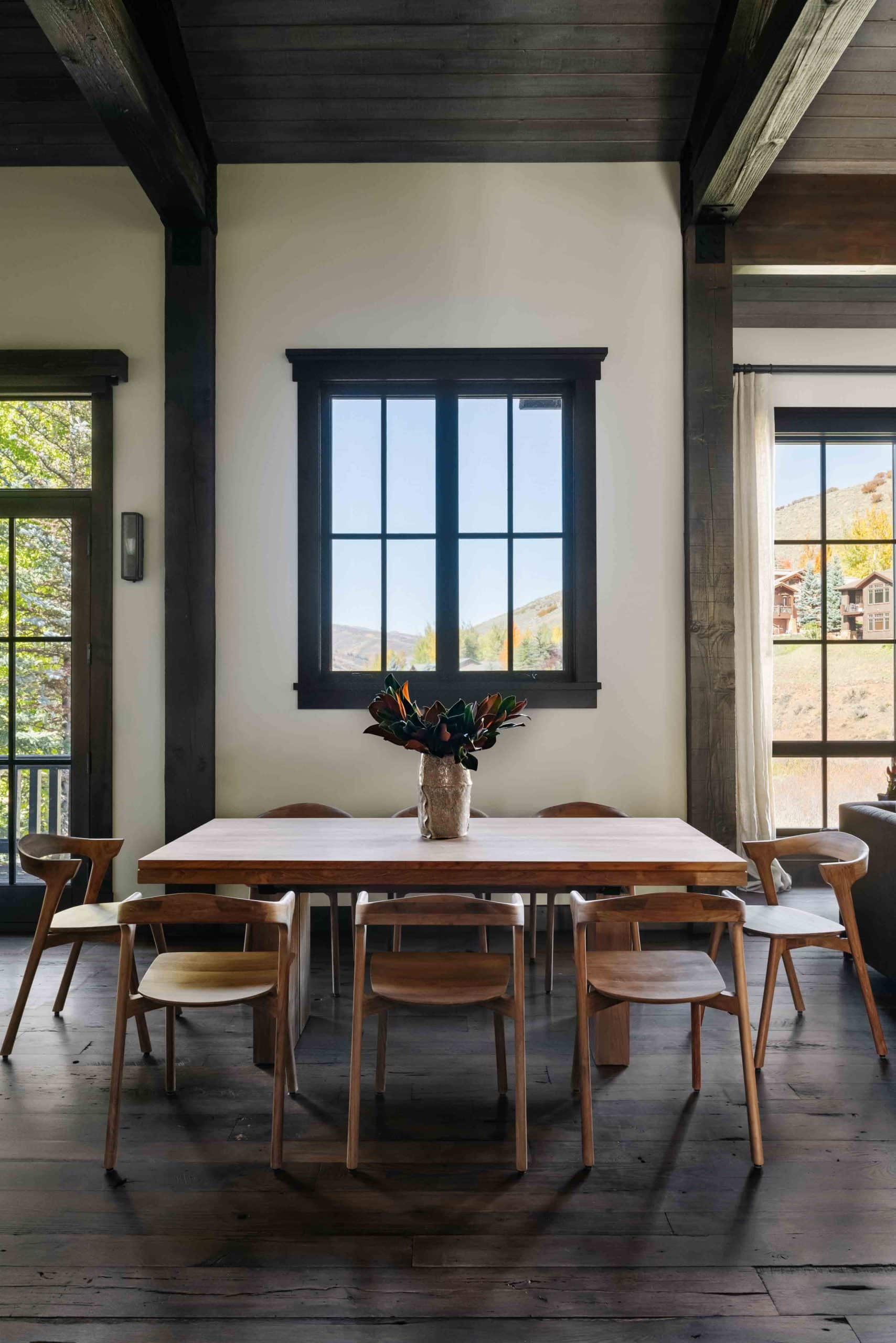 Dining area with a wood table, upholstered chairs, and a statement light fixture