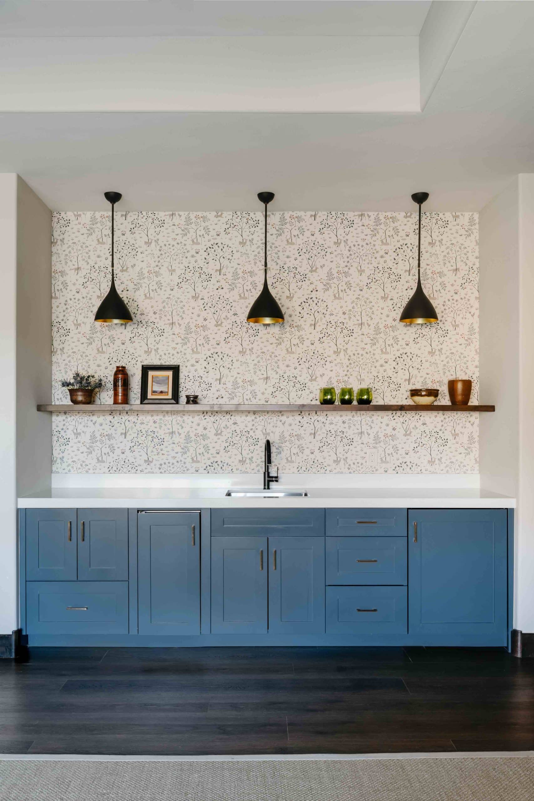 Downstairs kitchenette with cabinetry, counter seating, and durable finishes