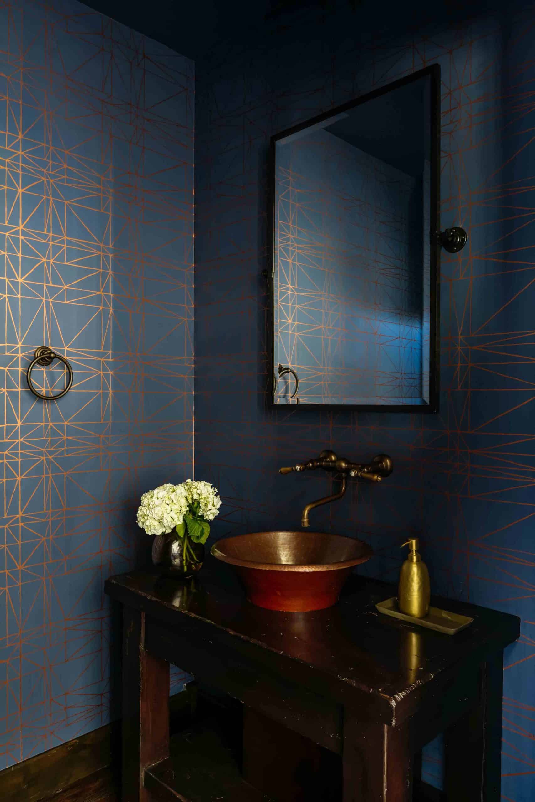 Powder bath with a vanity, framed mirror, and warm accent lighting